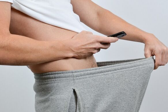 чоловік дивиться в штани на збільшений пеніс